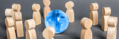 immagine con persone riunite attorno ad un globo terrestre